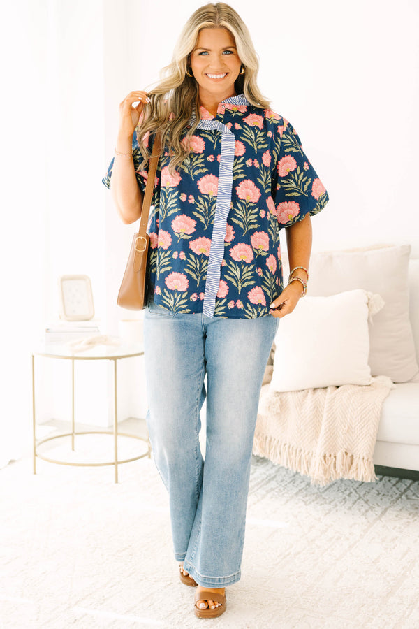 Navy floral top with elastic puff sleeves and blue and white striped ruffle trim.