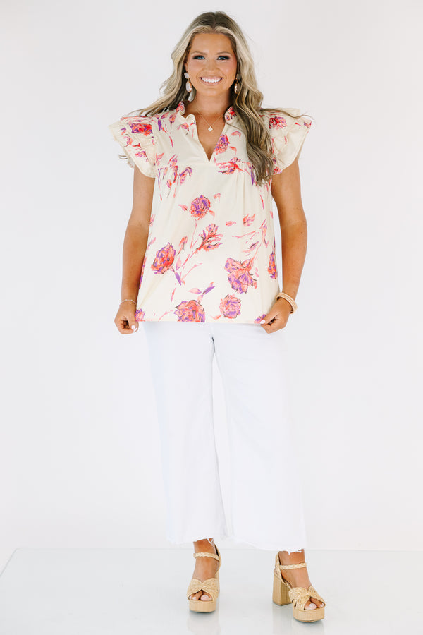 Plus Size cream floral v-neck top with flutter sleeves and a vibrant pink and purple flower print.
