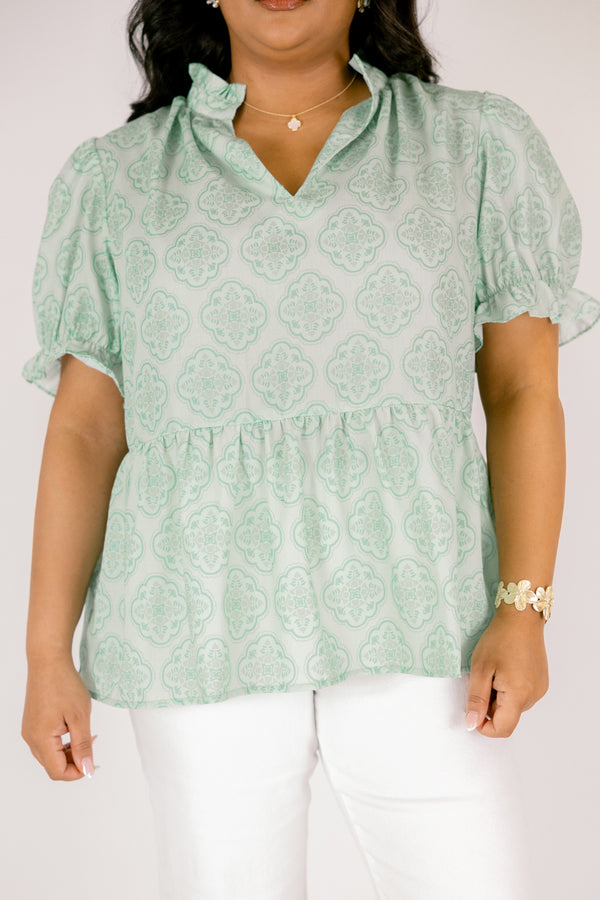 Chic Soul plus size clothing, green top with bubble sleeves that have a ruffle detail at the end of each sleeve as week as a ruffle detail on the collar a slight v-neckline and block abstract pattern throughout  
