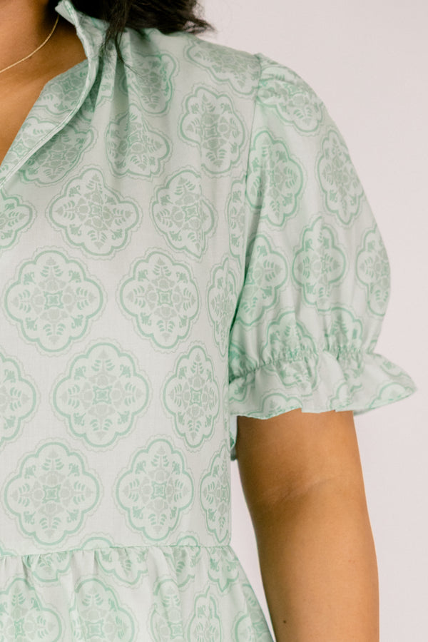 Chic Soul plus size clothing, green top with bubble sleeves that have a ruffle detail at the end of each sleeve as week as a ruffle detail on the collar a slight v-neckline and block abstract pattern throughout  
