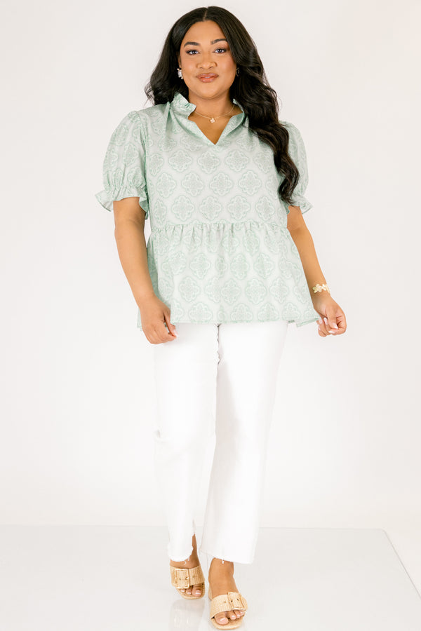 Chic Soul plus size clothing, green top with bubble sleeves that have a ruffle detail at the end of each sleeve as week as a ruffle detail on the collar a slight v-neckline and block abstract pattern throughout  
