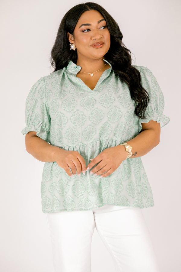 Chic Soul plus size clothing, green top with bubble sleeves that have a ruffle detail at the end of each sleeve as week as a ruffle detail on the collar a slight v-neckline and block abstract pattern throughout  
