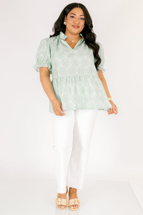 Chic Soul plus size clothing, green top with bubble sleeves that have a ruffle detail at the end of each sleeve as week as a ruffle detail on the collar a slight v-neckline and block abstract pattern throughout  
