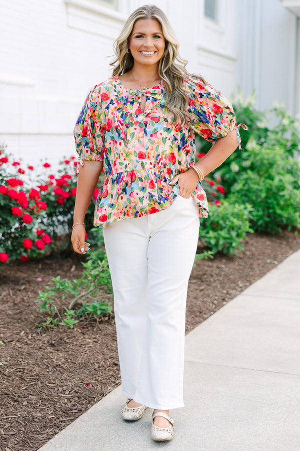 Plus size pink floral watercolor peplum top with puff sleeves and a bow neckline detail.