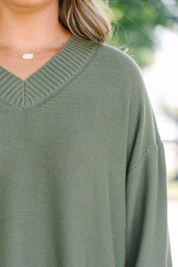Plus Size olive green v-neck sweater with a relaxed fit, ribbed trim, and long drop-shoulder sleeves.