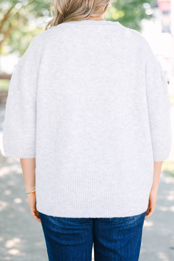 Plus Size gray v-neck cardigan with short sleeves, front patch pockets, and tortoise shell buttons.