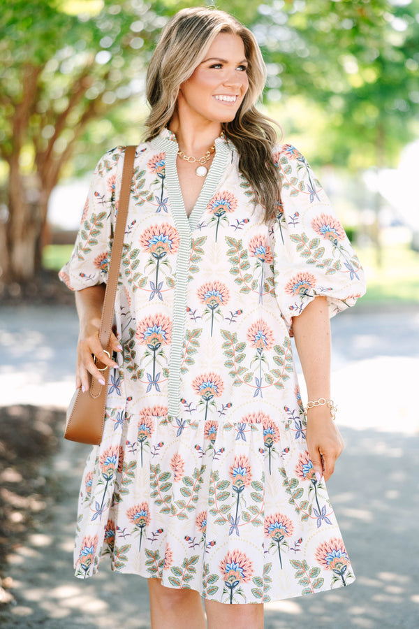 Plus size cream floral mini dress with a flowy fit, puff sleeves, and a striped V-neckline.