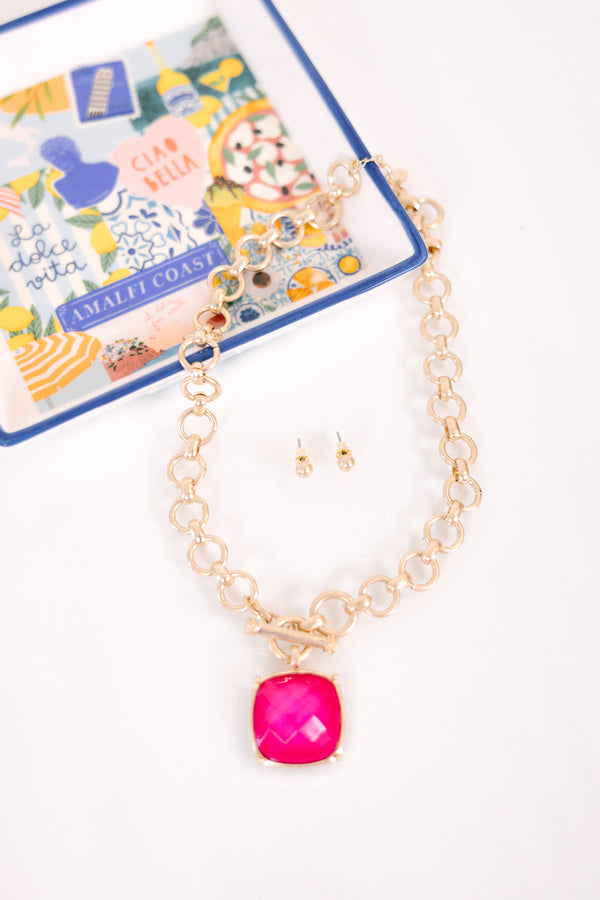 Plus Size gold chain necklace with a large fuchsia square pendant and matching gold stud earrings.