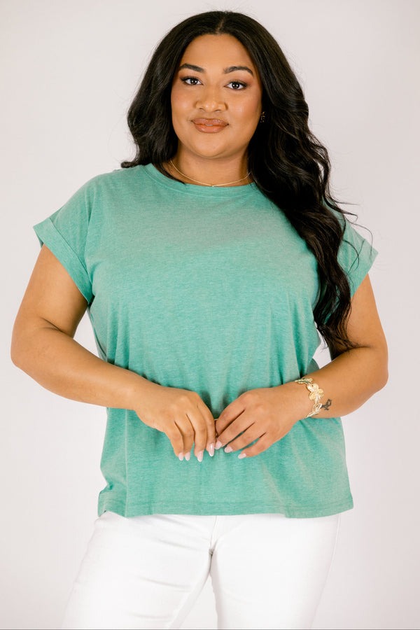 Plus Size heather kelly green crew neck cotton tee with cuffed short sleeves and white pants.