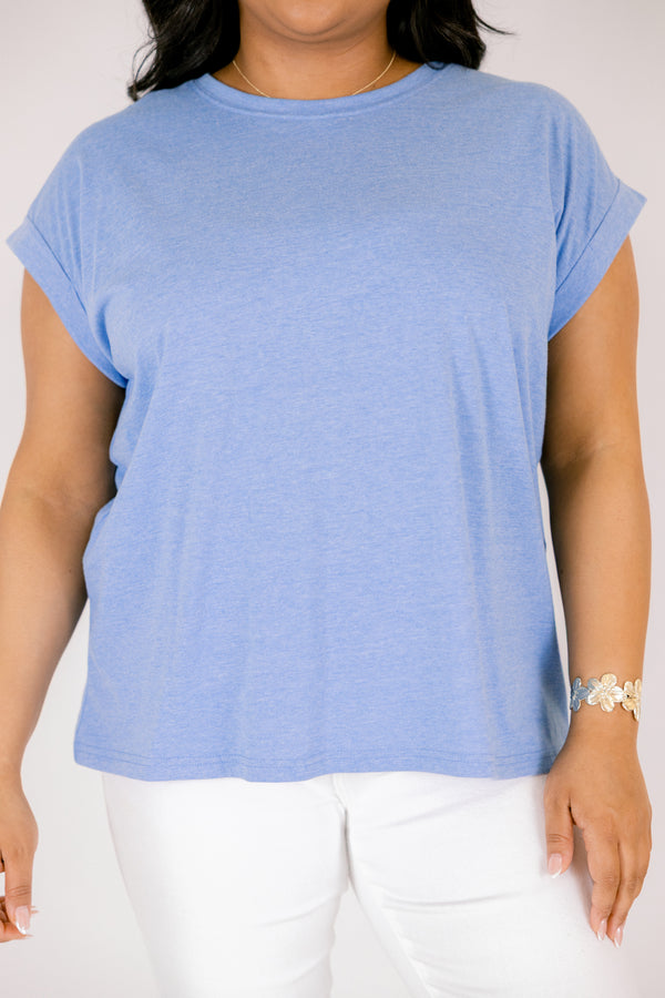 Plus Size heather ocean blue crew neck tee with cuffed short sleeves and white pants.