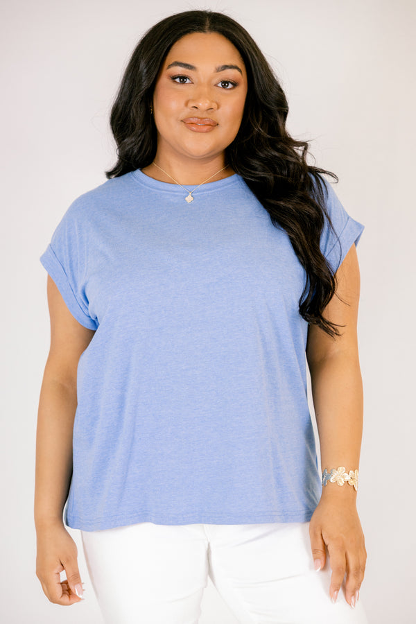 Plus Size heather ocean blue crew neck tee with cuffed short sleeves and white pants.