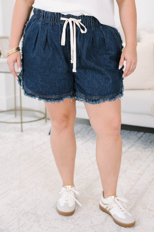 Plus size dark wash denim shorts with a drawstring elastic waist and frayed hem for a flowy fit.