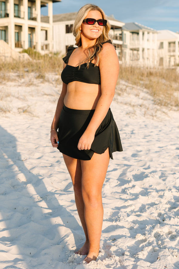 Plus Size black swim skirt with a high-waisted fit and a flared, ruffled hemline.