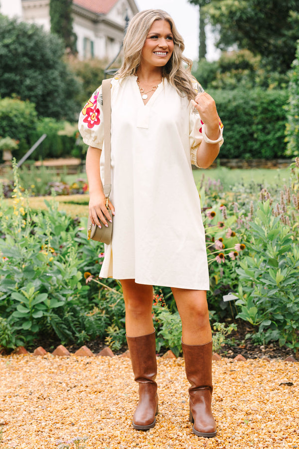 Plus Size cream cotton dress with a V-neckline and puff sleeves featuring colorful floral embroidery.