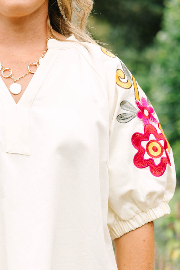 Plus Size cream cotton dress with a V-neckline and puff sleeves featuring colorful floral embroidery.