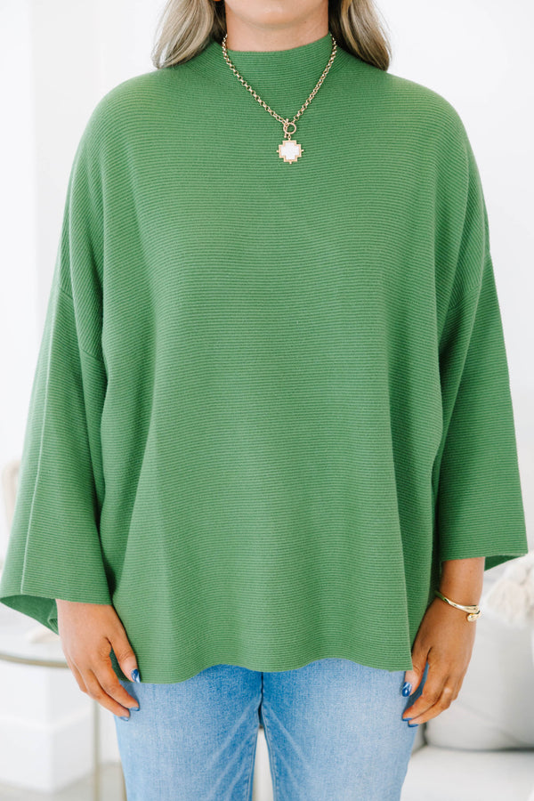 Plus size olive green ribbed sweater with a flowy oversized fit, mock neck, and wide bell sleeves.