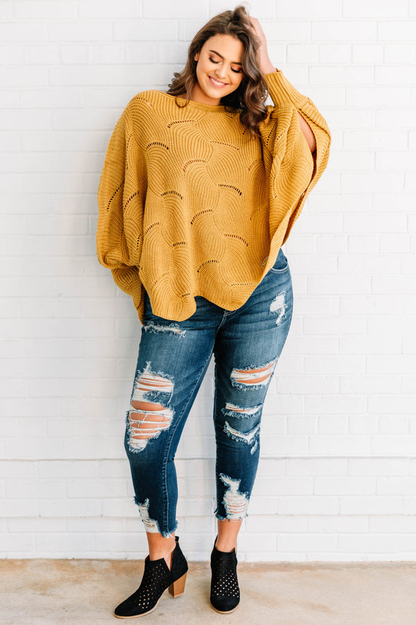Plus Size mustard yellow poncho-style sweater with a textured wave pattern and dark wash jeans.