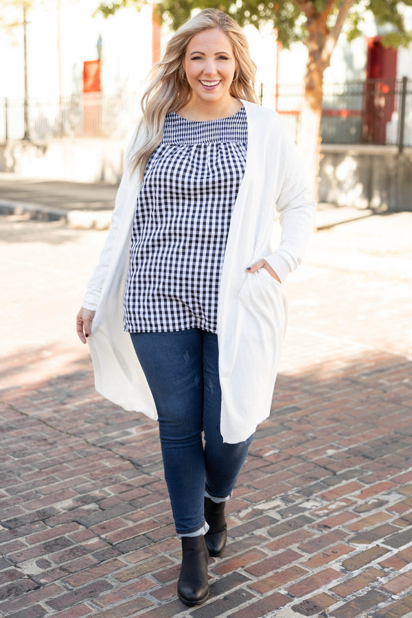Plus Size black and white gingham top with a smocked neckline and long puff sleeves.