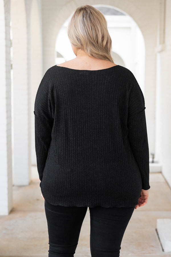 Plus Size black shimmery V-neck sweater with long sleeves and exposed seam detailing.