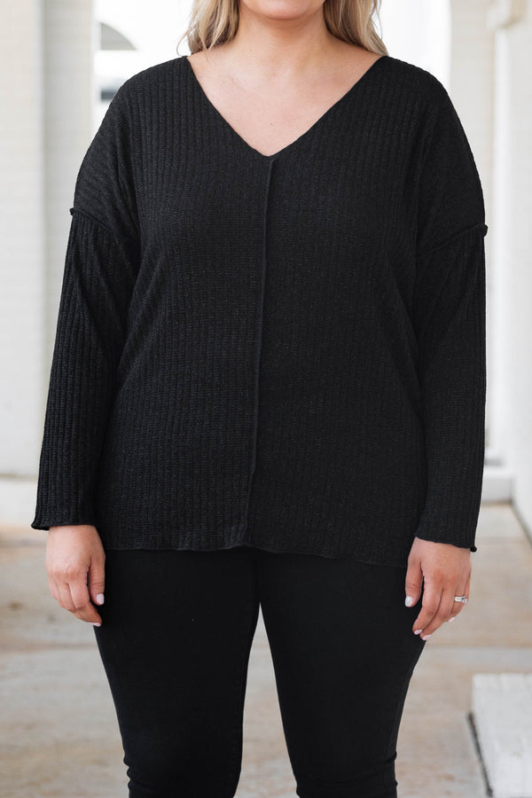 Plus Size black shimmery V-neck sweater with long sleeves and exposed seam detailing.