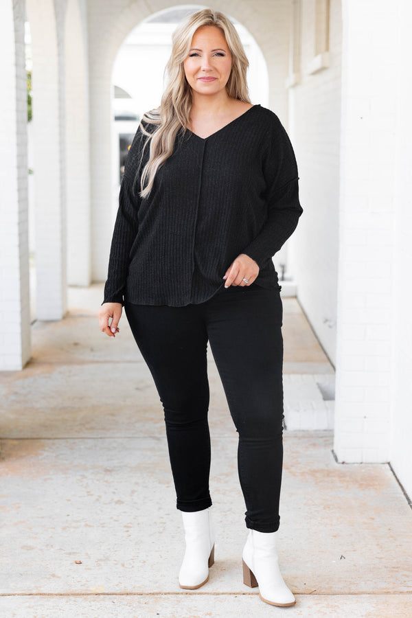 Plus Size black shimmery V-neck sweater with long sleeves and exposed seam detailing.
