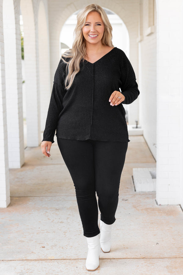 Plus Size black shimmery V-neck sweater with long sleeves and exposed seam detailing.