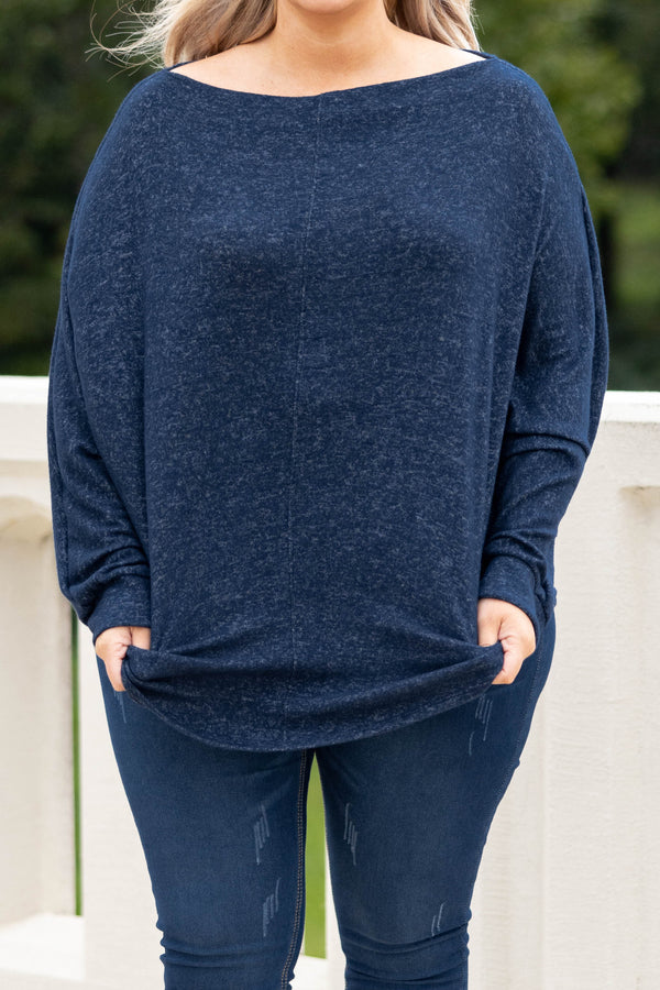 Plus Size navy blue long sleeve top with a boat neckline and relaxed fit paired with dark jeans.